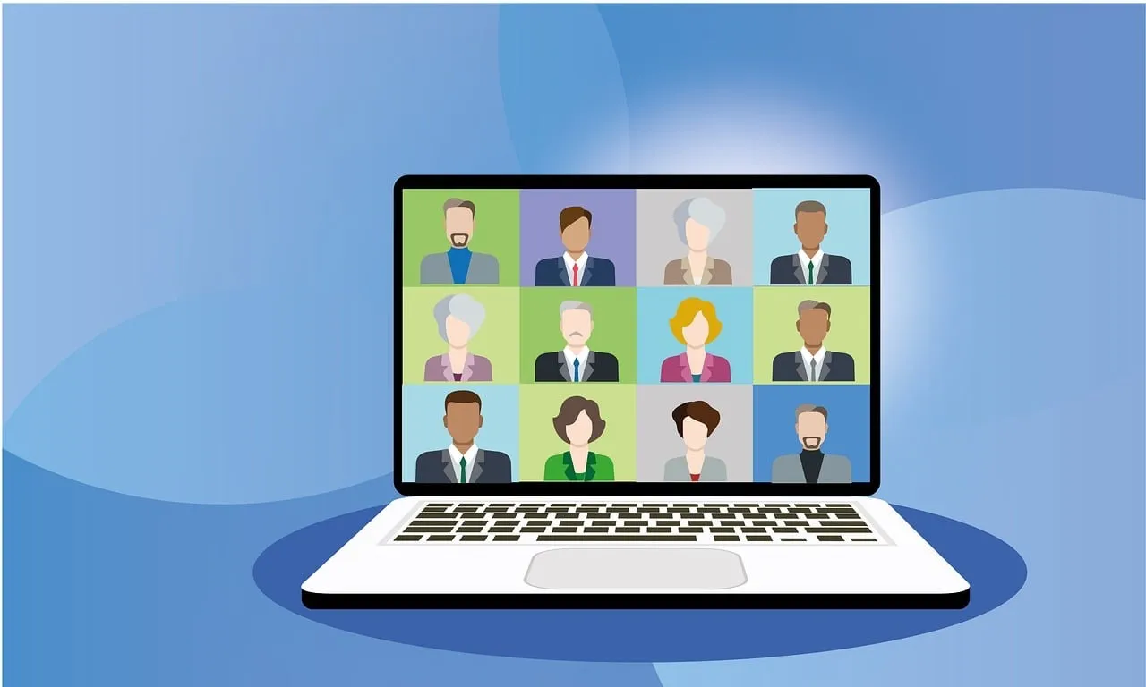 Laptop screen showing a 12-person video conference meeting with professionals.